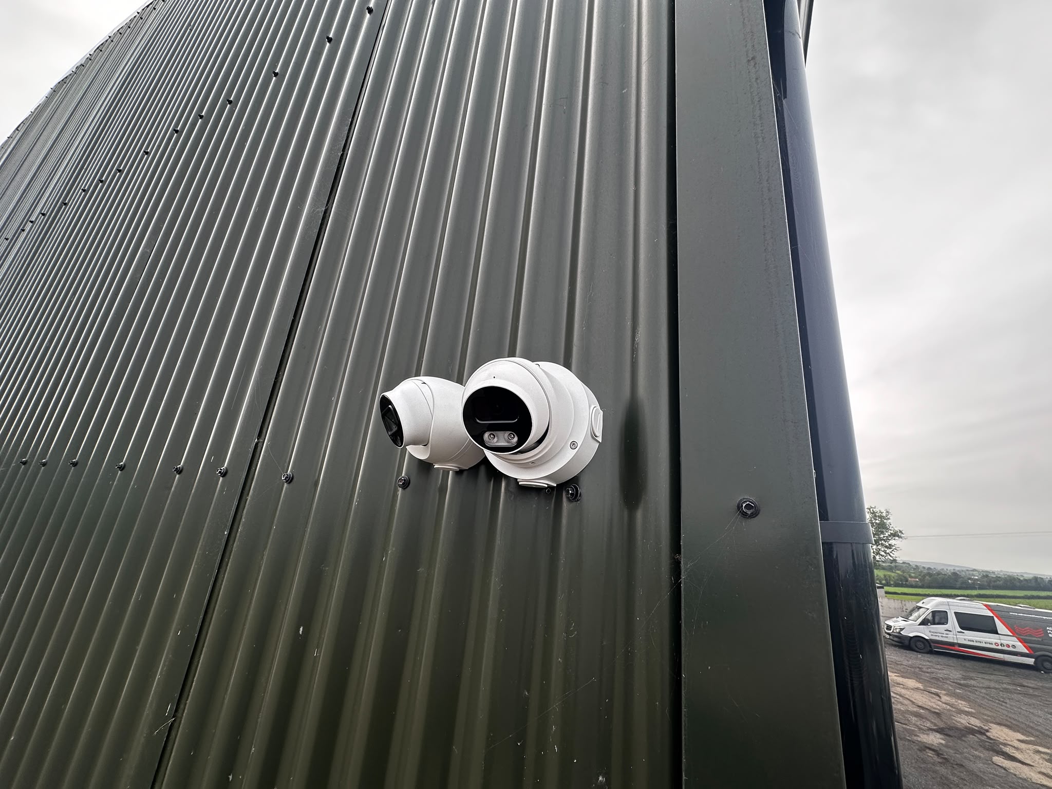 Two new HD security cameras mounted on the side of the building